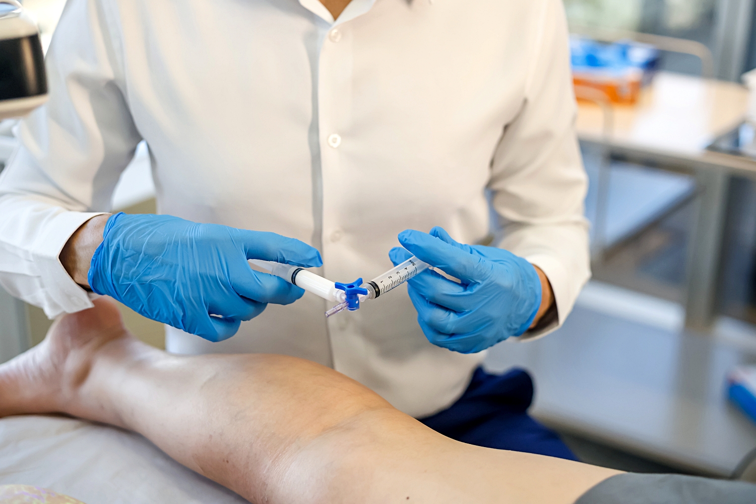 Médico preparando aplicação para tratamento de veias na perna